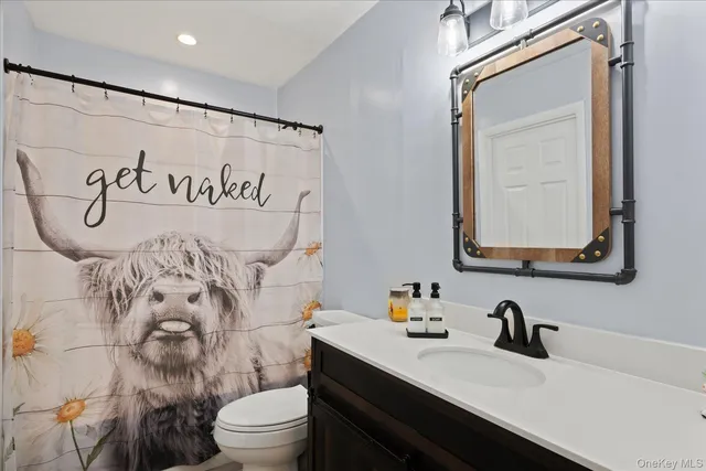 a bathroom with a granite countertop sink mirror a toilet and a shower