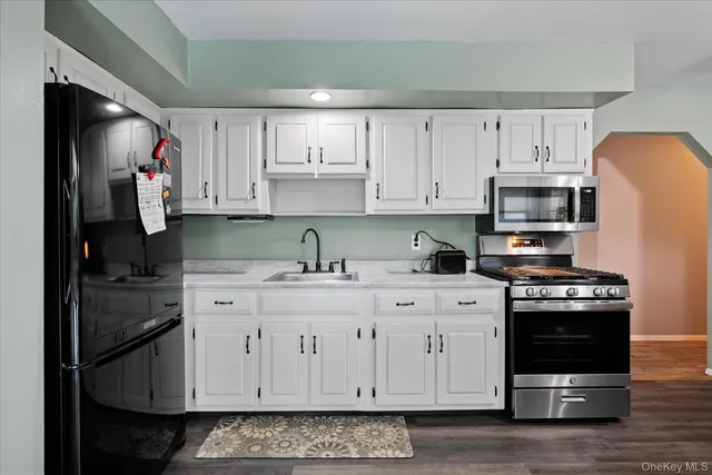 a kitchen with stainless steel appliances granite countertop a stove a sink and a refrigerator
