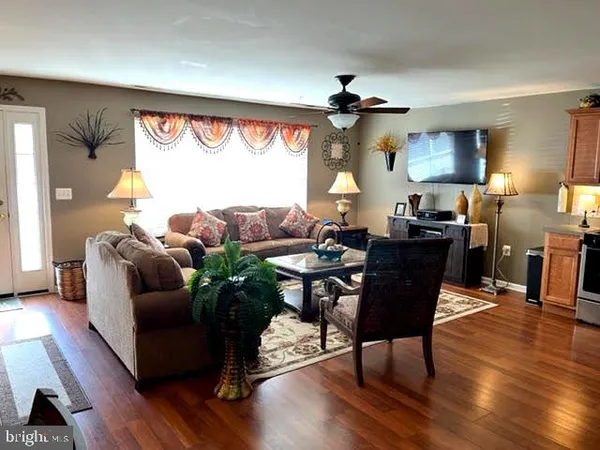 a living room with furniture a window and a flat screen tv