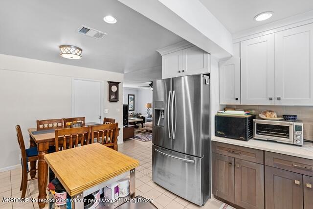 14 Bamboo Lane Jupiter, FL 33458 - Photo 17 of 33 a kitchen with stainless steel appliances a refrigerator a stove a dining table and chairs