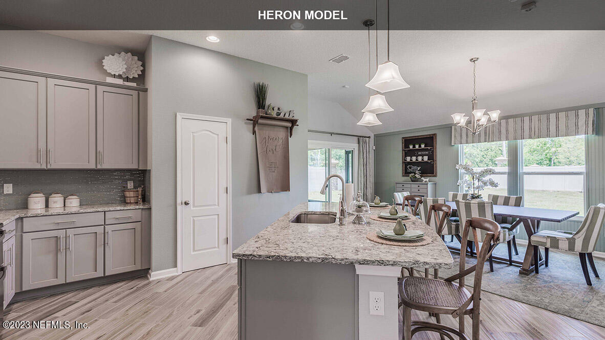 65744 Edgewater Drive Yulee, FL 32097 - Photo 12 of 45 a kitchen with kitchen island granite countertop a sink cabinets and wooden floor