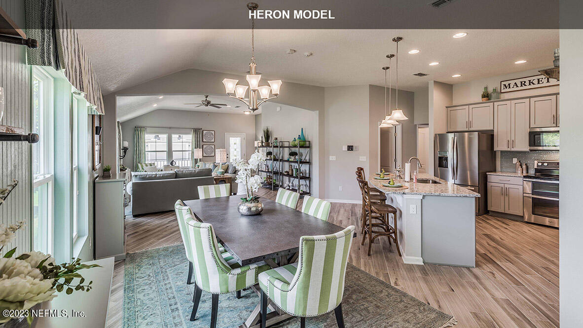 65744 Edgewater Drive Yulee, FL 32097 - Photo 9 of 45 a dining room with kitchen island stainless steel appliances furniture a chandelier and kitchen view