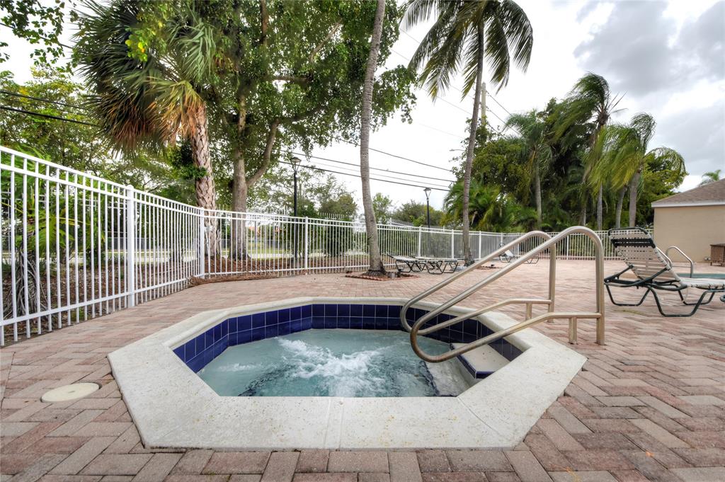 231 Southwest 113th Way, Unit 231 Pembroke Pines, FL 33025 - Photo 36 of 39 a view of swimming pool with lounge chair and dinning table under palm trees