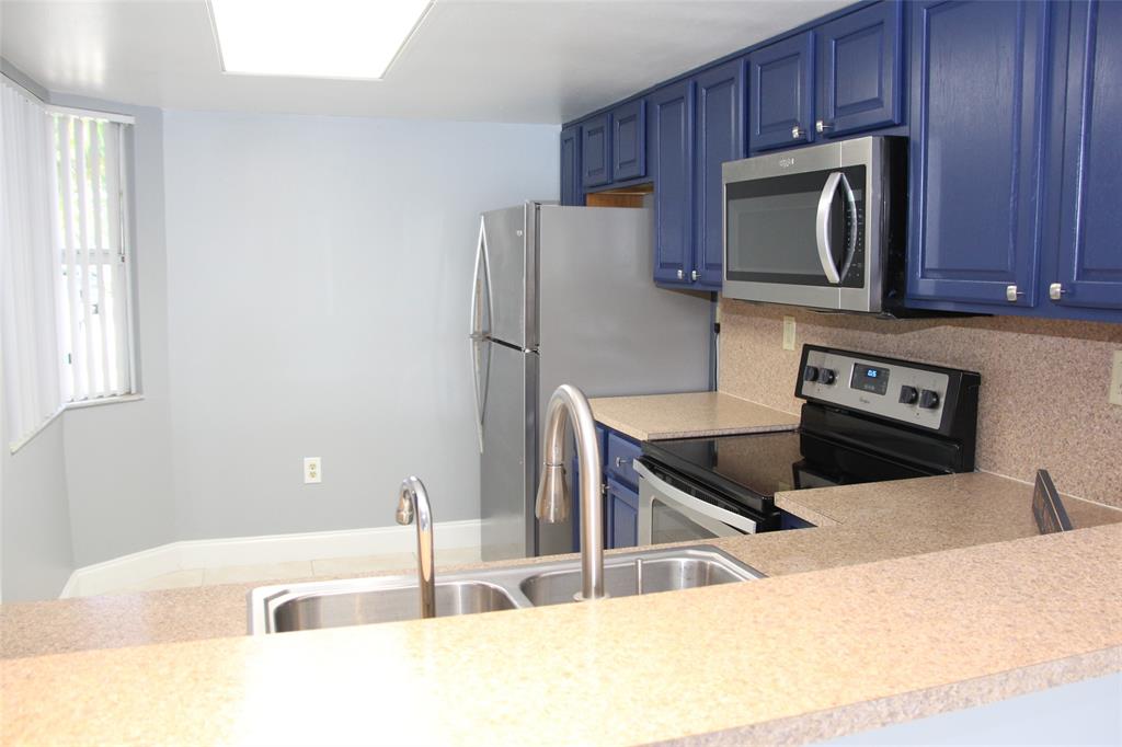 231 Southwest 113th Way, Unit 231 Pembroke Pines, FL 33025 - Photo 7 of 39 a kitchen with stainless steel appliances wooden cabinets and a stove