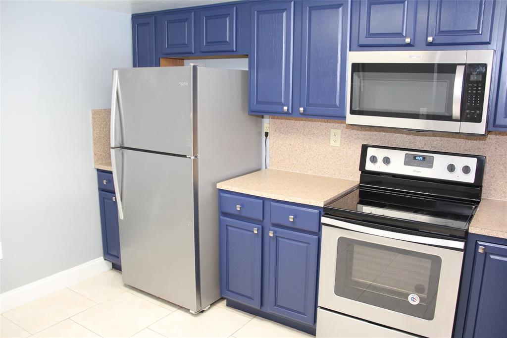 231 Southwest 113th Way, Unit 231 Pembroke Pines, FL 33025 - Photo 8 of 39 a white refrigerator freezer and a stove sitting inside of a kitchen with granite countertop wooden cabinets