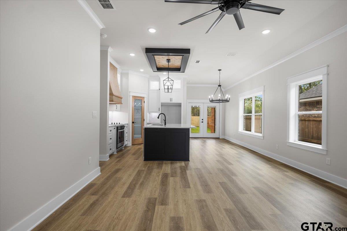 3022 West Rose Street Tyler, TX 75701 - Photo 10 of 46 a view of a big room with wooden floor a ceiling fan and windows