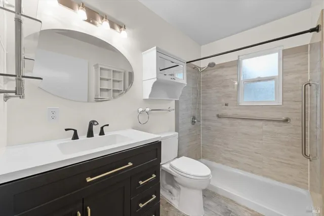 a bathroom with a sink a toilet and shower