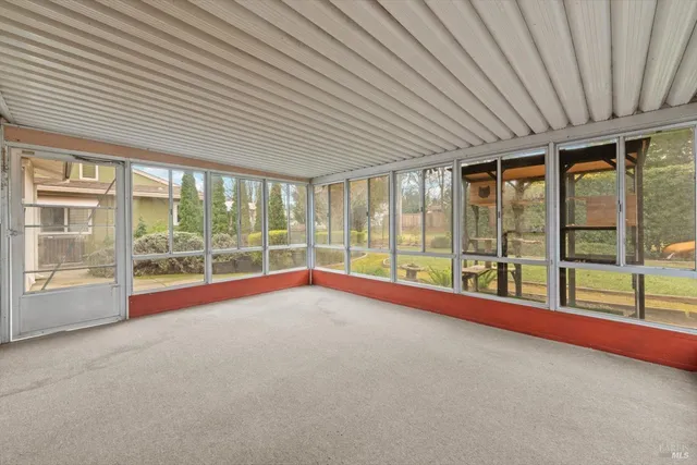 a view of an empty room with windows and a balcony