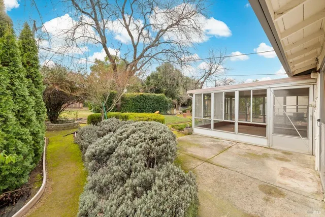 a view of a house with backyard and sitting area