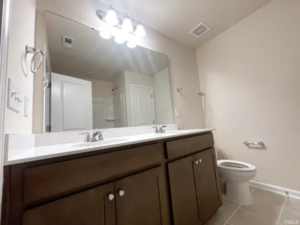 a bathroom with a double vanity sink mirror and toilet