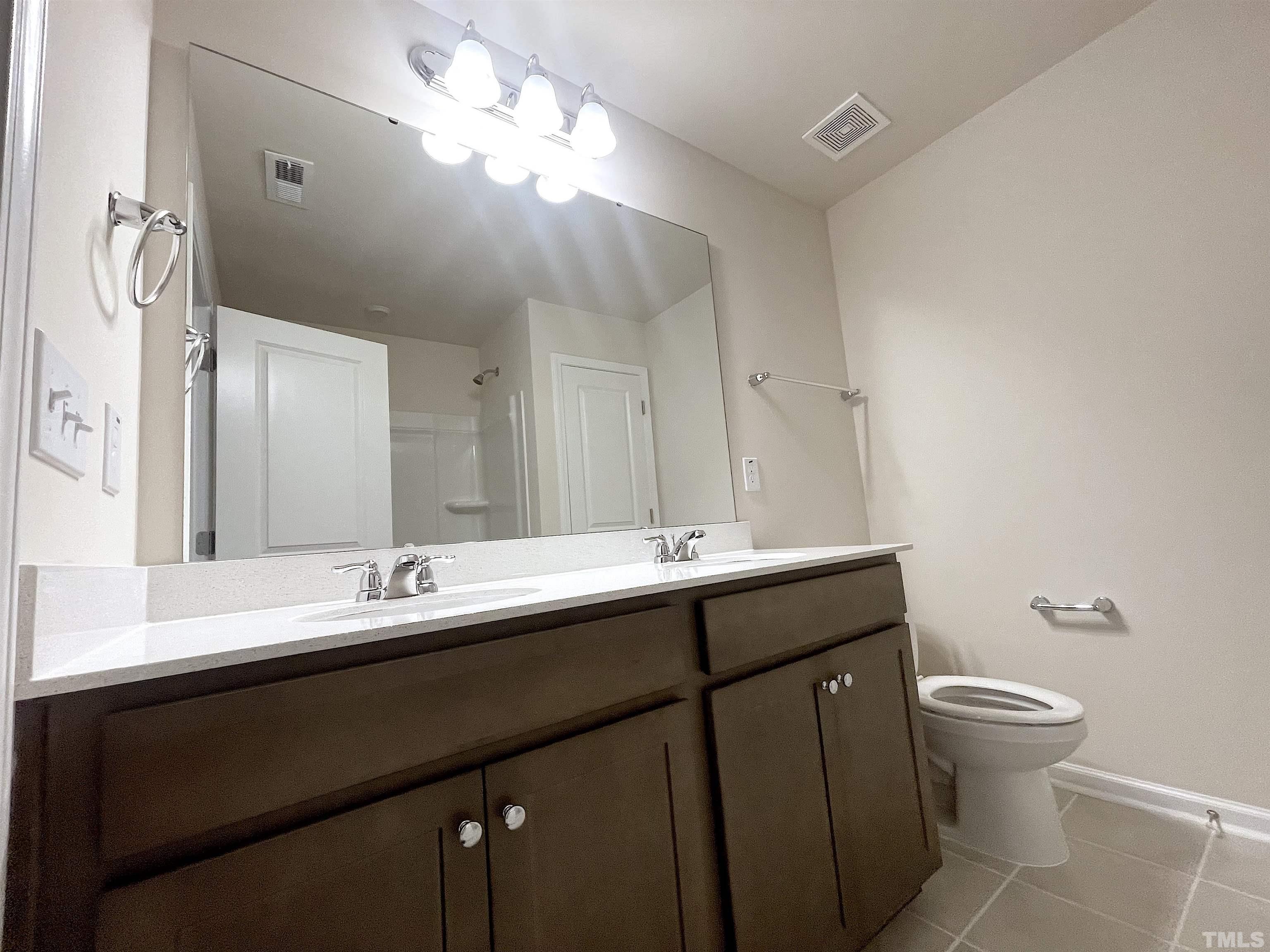 4906 Megara Run Raleigh, NC 27603 - Photo 17 of 30 a bathroom with a double vanity sink mirror and toilet