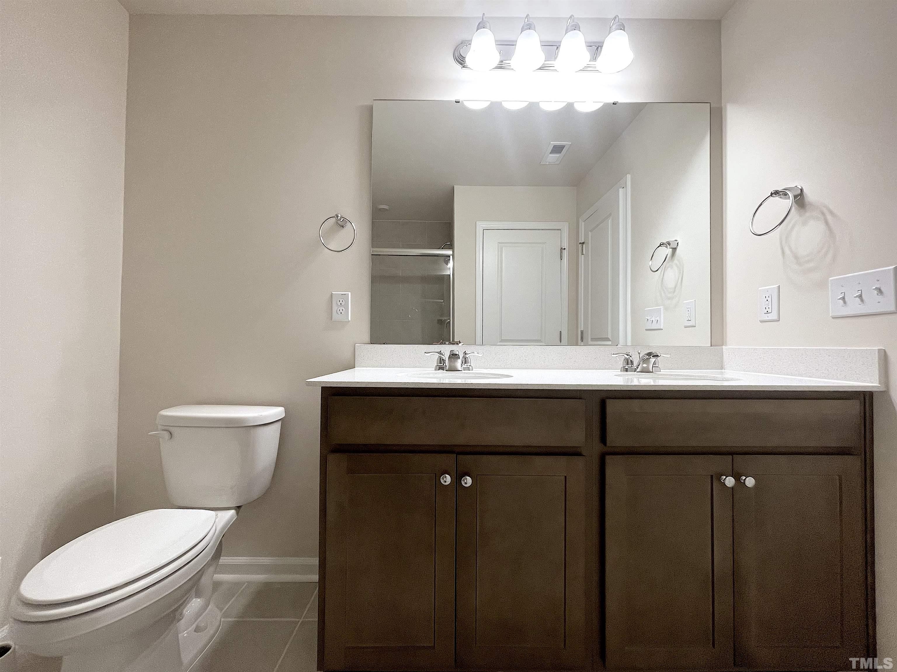 4906 Megara Run Raleigh, NC 27603 - Photo 22 of 30 a bathroom with a toilet sink and mirror