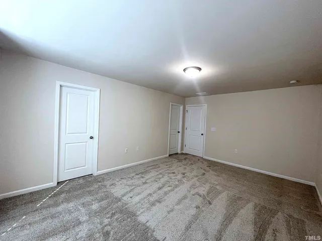 a view of an empty room and kitchen