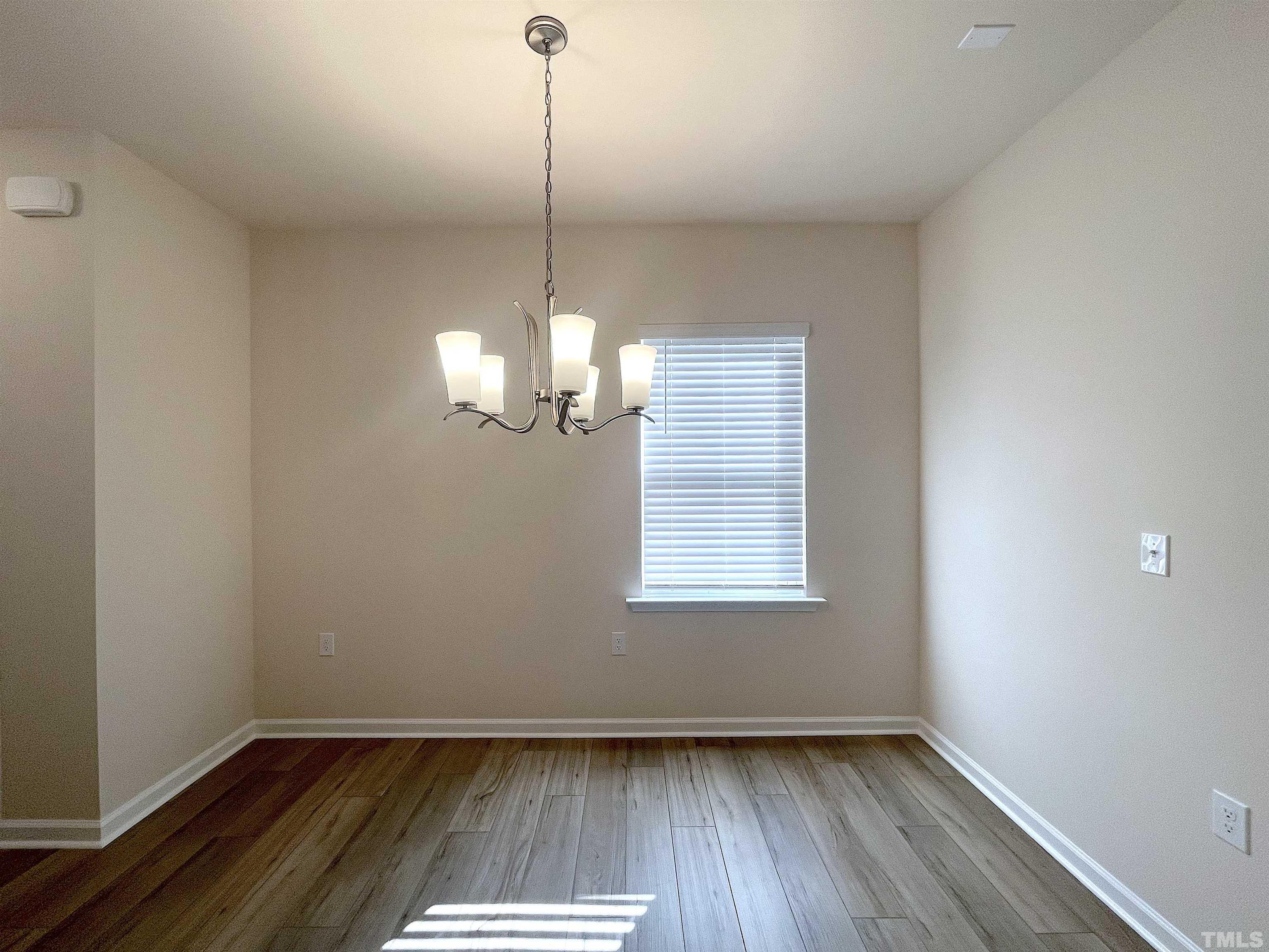 4906 Megara Run Raleigh, NC 27603 - Photo 5 of 30 a view of empty room with wooden floor and chandelier