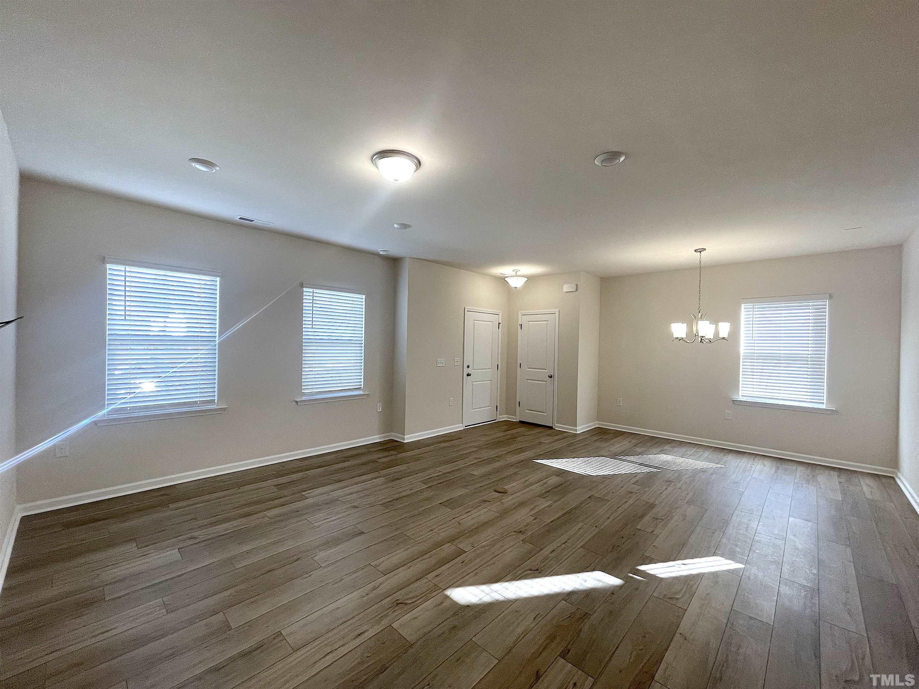 4906 Megara Run Raleigh, NC 27603 - Photo 7 of 30 a view of an empty room with wooden floor and a window