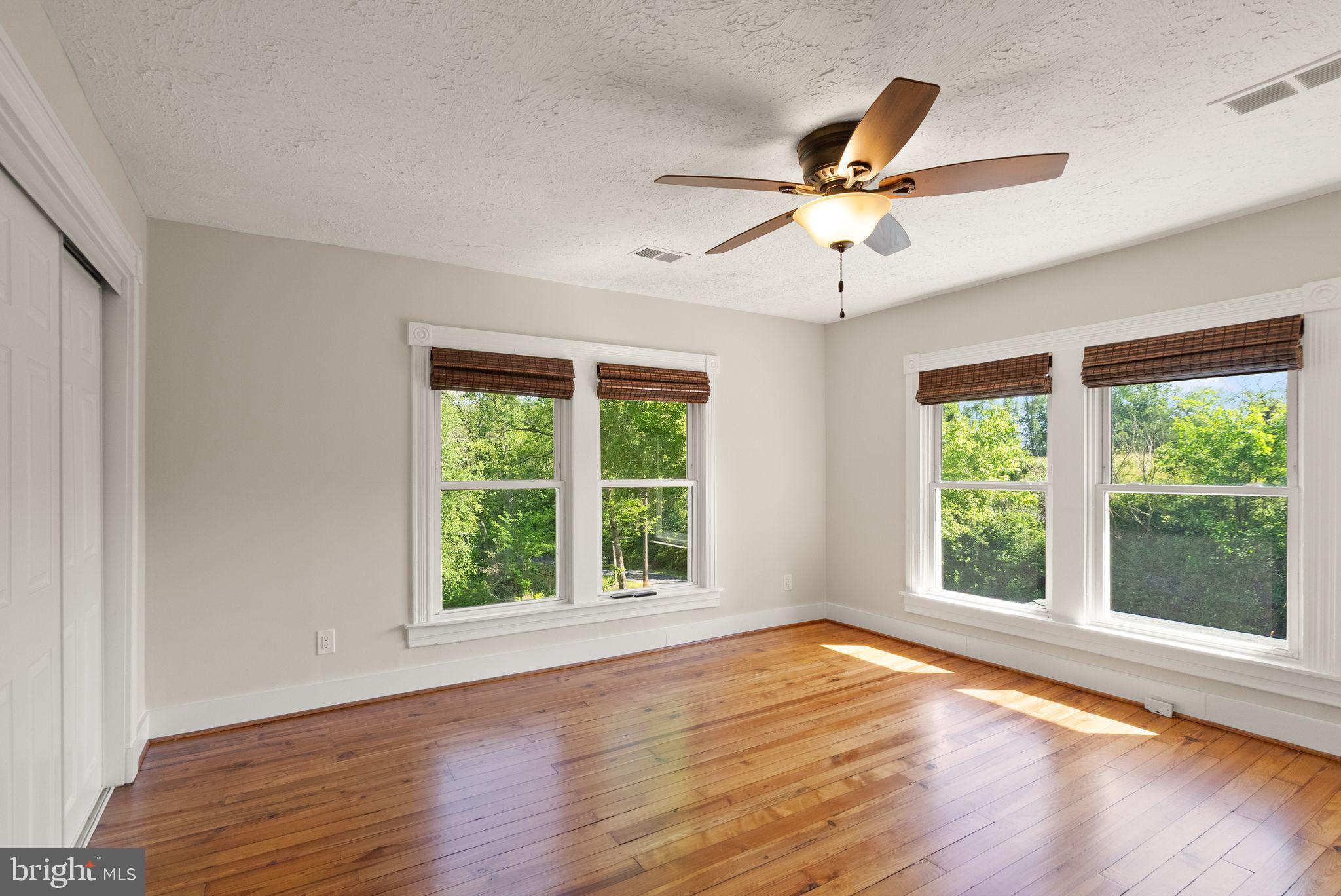 37151 Branchriver Road Purcellville, VA 20132 - Photo 32 of 63 a view of an empty room with wooden floor and a window