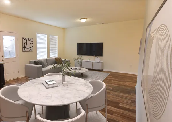 a living room with furniture a flat screen tv and wooden floor
