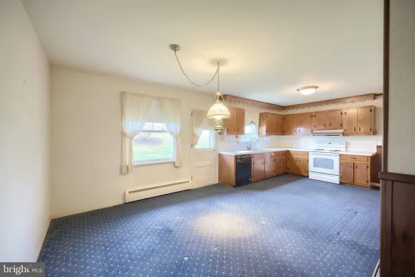 a view of a kitchen with a sink and dishwasher a kitchen island with wooden cabinets