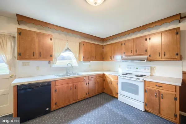 a kitchen with white cabinets appliances and a sink