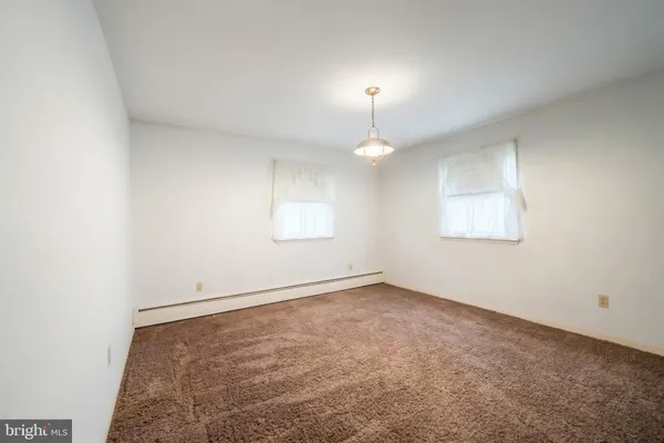 an empty room with a lamp and a chandelier fan