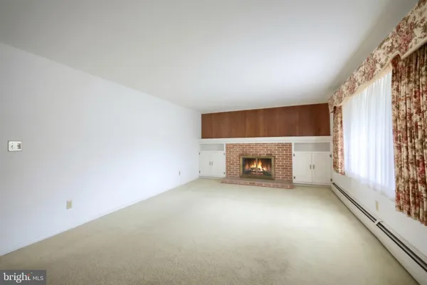 an empty room with a fireplace and window