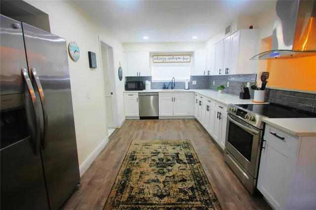 a kitchen with stainless steel appliances granite countertop a refrigerator and a stove