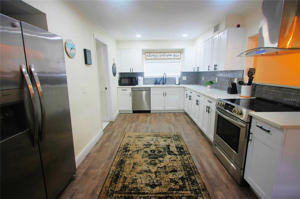 6602 North 9th Street Tampa, FL 33604 - Photo 4 of 22 a kitchen with stainless steel appliances granite countertop a refrigerator and a stove