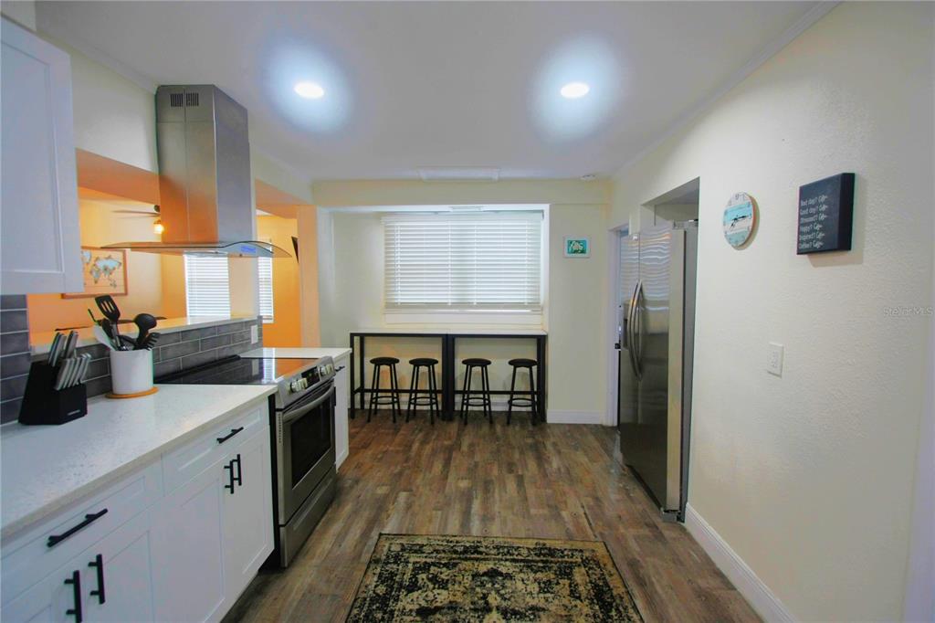 6602 North 9th Street Tampa, FL 33604 - Photo 7 of 22 a kitchen with stainless steel appliances granite countertop a stove a sink dishwasher and a refrigerator with wooden floor