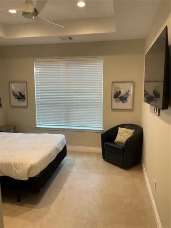 a spacious bedroom with a bed and a flat screen tv