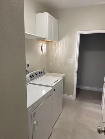 a utility room with cabinets washer and dryer