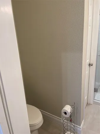 a white toilet sitting next to a shower
