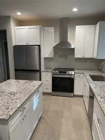 a kitchen with granite countertop a sink stove and refrigerator