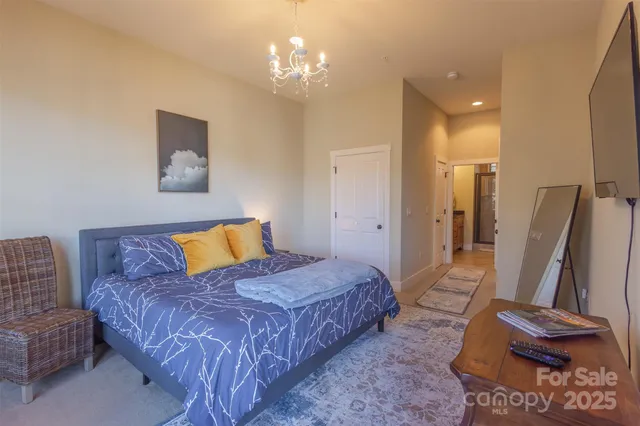 a spacious bedroom with a bed and a chandelier