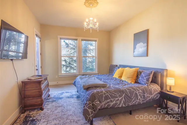 a bedroom with a bed and a chandelier