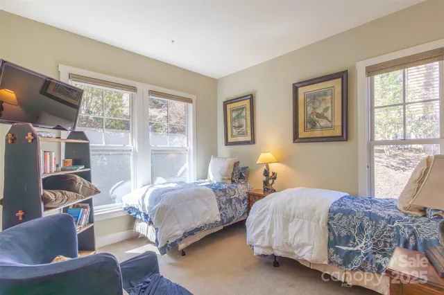 a bedroom with two beds and a large window