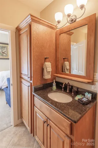 a bathroom with a granite countertop sink and a mirror