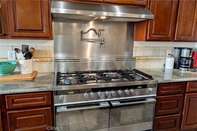 a bathroom with a granite countertop sink a toilet and mirror