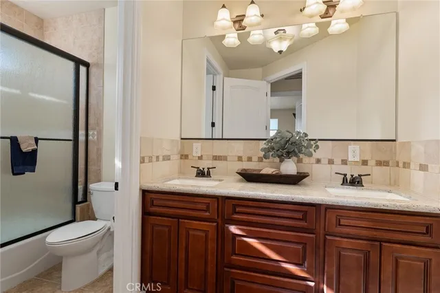 a bath room with a granite countertop sink and a mirror