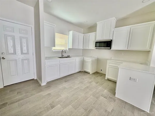 a kitchen with white cabinets and white appliances