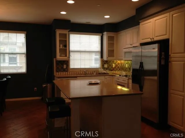 a kitchen with stainless steel appliances granite countertop a sink a stove and a refrigerator