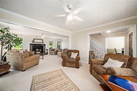 a living room with furniture a fireplace and a chandelier