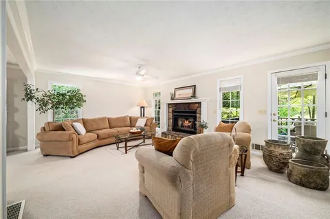 a living room with furniture a fireplace and a large window