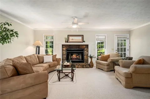 a living room with furniture a large window and a fireplace