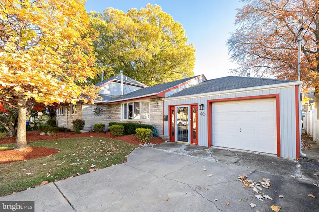 a front view of a house with a yard and trees