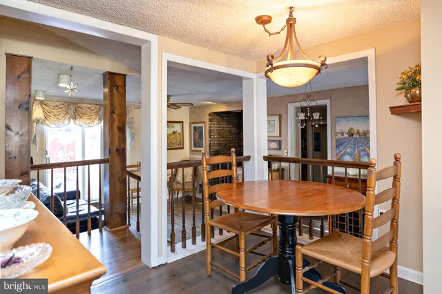 a kitchen with stainless steel appliances granite countertop wooden cabinets a dining table and chairs