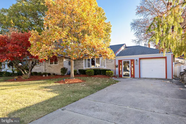 a front view of a house with a yard and trees