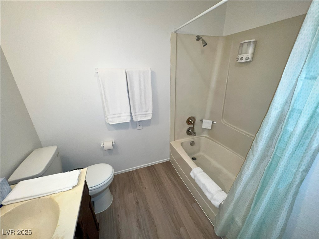 4650 Koval Lane, Unit 14C Las Vegas, NV 89109 - Photo 13 of 14 Bathroom featuring wood finished floors, shower / tub combo with curtain, and vanity