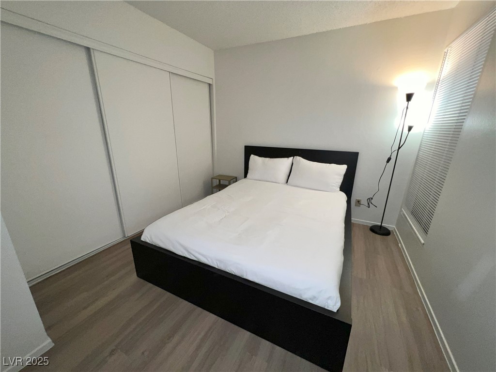 4650 Koval Lane, Unit 14C Las Vegas, NV 89109 - Photo 3 of 14 Bedroom featuring wood finished floors, a closet, and a textured ceiling