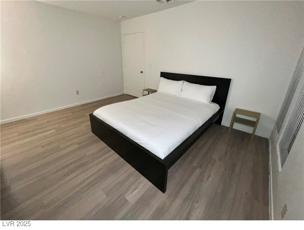 4650 Koval Lane, Unit 14C Las Vegas, NV 89109 - Photo 6 of 14 Bedroom featuring wood finished floors and baseboards