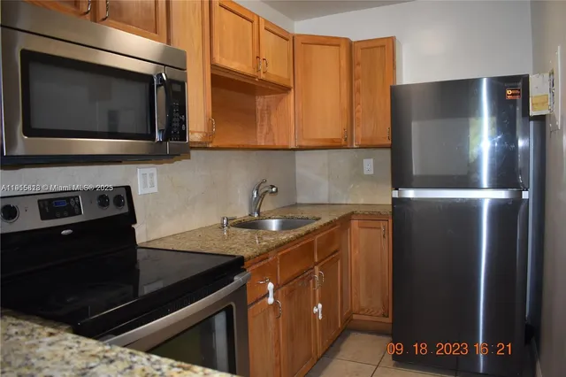 a kitchen with stainless steel appliances granite countertop a refrigerator and a stove top oven